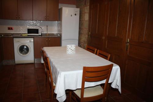 a kitchen with a table with chairs and a refrigerator at Apartamentos Rio Mora in Mora de Rubielos