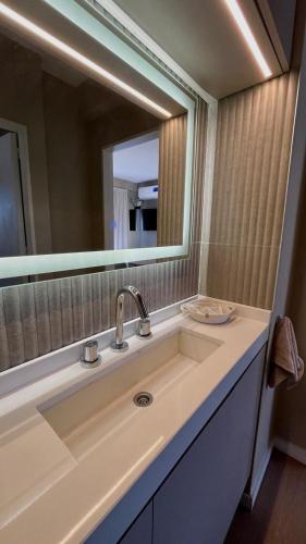 a bathroom with a sink and a large mirror at Vcp urban suites in Villa Carlos Paz