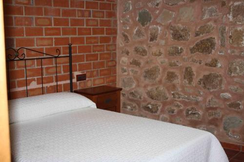 a bedroom with a brick wall and a bed at Apartamentos Rio Mora in Mora de Rubielos