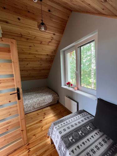 a small room with a bed and a window at Rumelówka in Wawrowice
