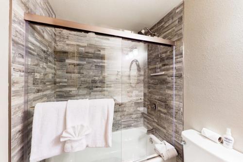 a bathroom with a tub and a shower with towels at Mountainside Retreat in Frisco