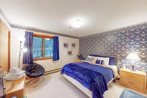 a bedroom with a bed and a chair and a window at Ober Tal Getaway in Stratton