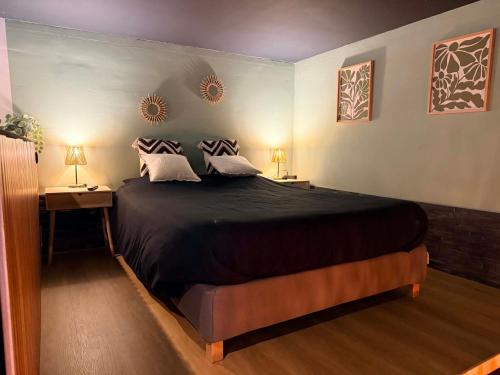 a bedroom with a large black bed with two lamps at Au bât Tournai chambre zen in Tournai