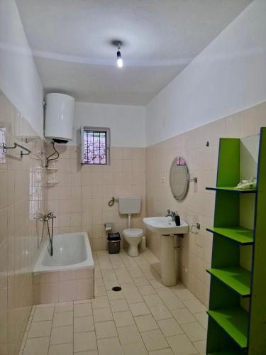a bathroom with a tub and a toilet and a sink at Himara Holiday House in Himare