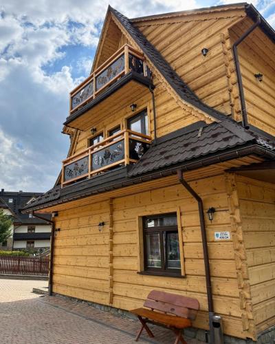 a wooden house with a balcony on top of it at Kowali Wierch - blisko Centrum i Dworca PKP in Zakopane