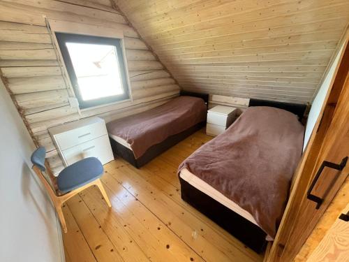a small room with two beds and a window at Domki letniskowe Malina 4 in Gawrony