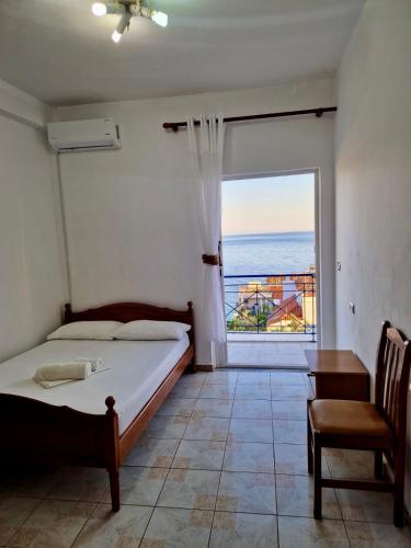 a bedroom with a bed and a large window at Himara Holiday House in Himare