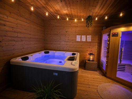 a jacuzzi tub in a wooden room with lights at Les dunes le Lima in Quend-Plage