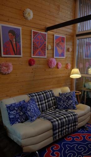 a couch in a living room with paintings on the wall at The Doma in Oral