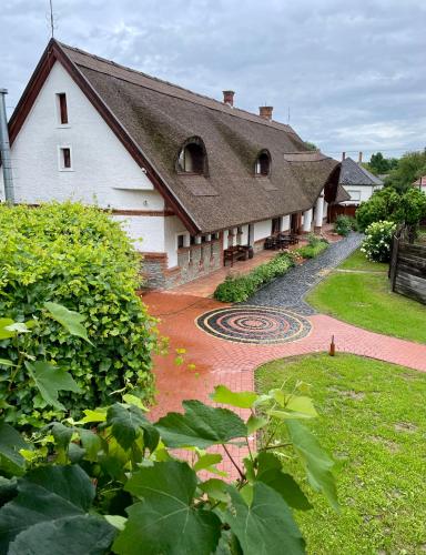 a large white house with a garden and a building at St.Michael Panzió Lovaspark in Vasszentmihály