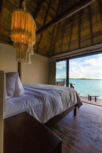 a bedroom with a bed and a chandelier at Akalki Hotel y Centro Holistico in Bacalar