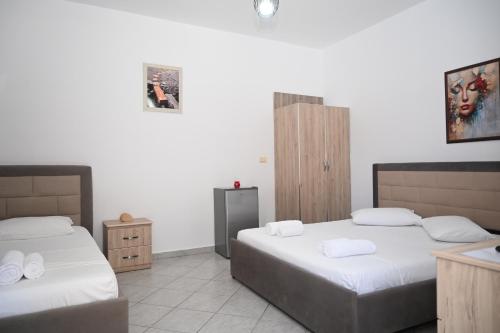 two beds in a room with white walls at Mandi's Apartment in Ksamil