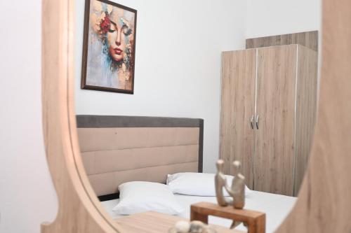 a mirror in a bedroom with a bed and a painting at Mandi's Apartment in Ksamil