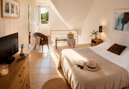 a bedroom with a bed and a television and a table at APPART HÔTEL MON CALME in Piriac-sur-Mer