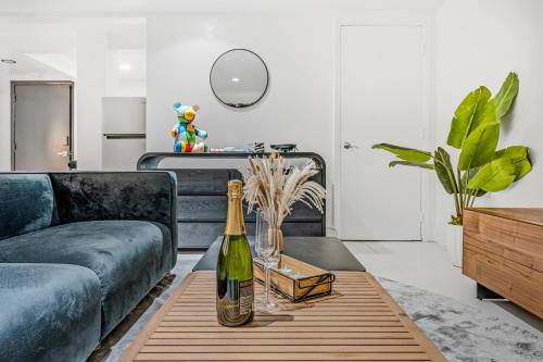 a living room with a couch and a bottle of wine on a table at Hotel Harrison On the Beach in Miami Beach