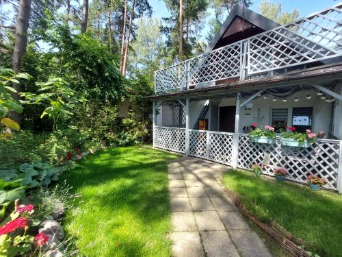a house with a porch with flowers in the yard at Przystań Arizona Ostróda in Ostróda