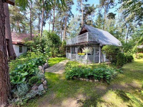 a white house with a porch in a yard at Przystań Arizona Ostróda in Ostróda