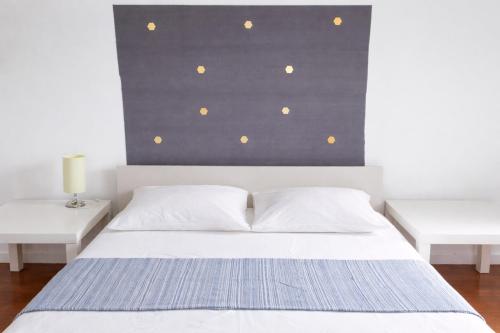 a bedroom with a white bed with two white tables at Estádio da Luz Room in Lisbon