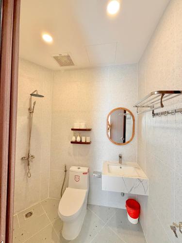 a bathroom with a toilet and a sink and a mirror at Olivea Boutique Hotel Phu Quoc in Phú Quốc