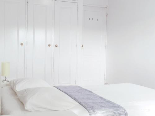 a white bedroom with white cabinets and a bed at Estádio da Luz Room in Lisbon
