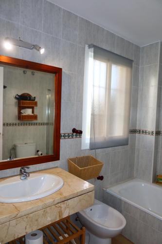 a bathroom with a sink and a tub and a toilet at Divi Apartments Costa Ballena in Costa Ballena