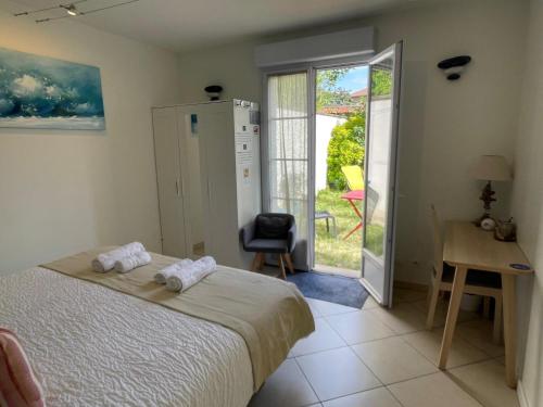 a bedroom with a bed and a door to a patio at Hôtel et Chambres d'hôtes Les Mureaux - Les chambres de la Marina in Les Mureaux