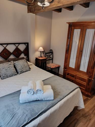 a bedroom with a bed with towels on it at Apartamentos EL Wala in Hervás