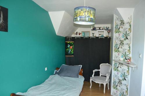 a bedroom with a bed and a chair in it at maison pour vieilles charrues in Maël-Carhaix