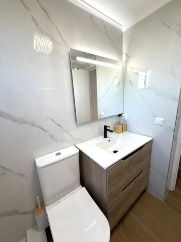 a bathroom with a toilet and a sink and a mirror at Cute get away apartment RBLD in La Mata