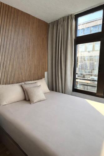 a bedroom with a large white bed with a window at Cute get away apartment RBLD in La Mata