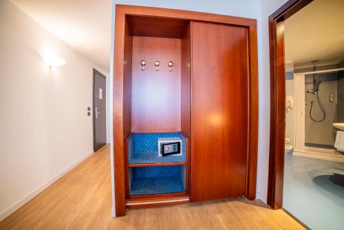 a wooden elevator with a clock on it in a room at Hotel Donizetti in Lallio