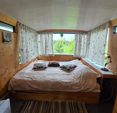a bedroom with a bed with two pillows on it at Atomi CountryBus in Aucugals