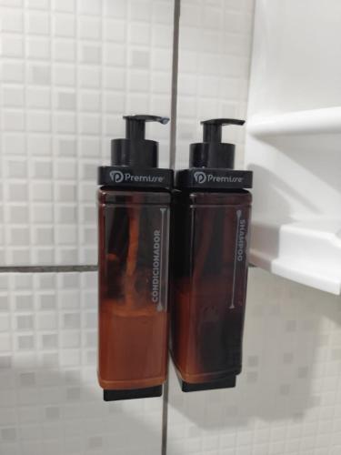 two brown bottles sitting on a counter in a bathroom at Recanto Vó Eni in Gramado