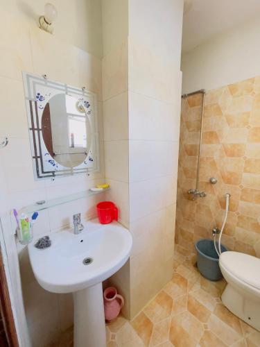 a bathroom with a sink and a toilet and a mirror at Stay lux yellow in Islamabad