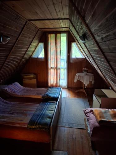 a attic bedroom with two beds and a table at U Cecylii in Rowy