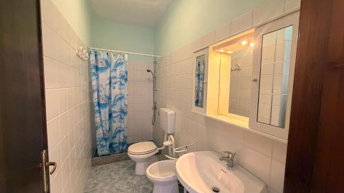 a bathroom with a sink and a toilet and a mirror at Isola Rossa Appartamenti vista mare in collina in Isola Rossa