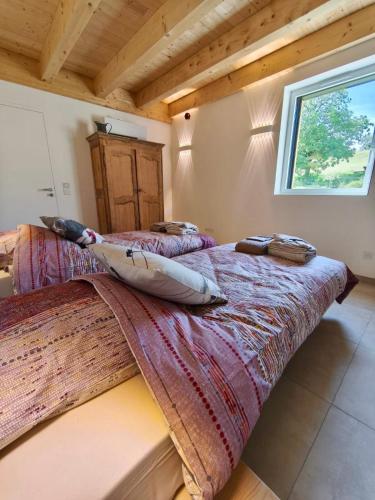 two beds in a room with wooden ceilings at Gîte de la Vonne in Vimines