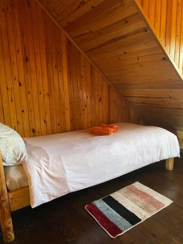 a bed in a room with a wooden ceiling at Silk Way in Ureki