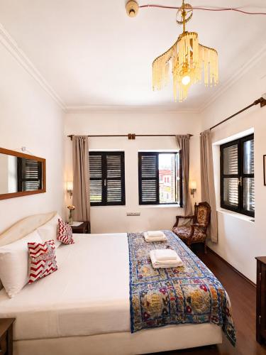 ein Schlafzimmer mit einem großen Bett und einem Kronleuchter in der Unterkunft Hadrianus Pansion in Antalya