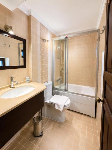 ein Badezimmer mit Waschbecken, Toilette und Dusche in der Unterkunft Hadrianus Pansion in Antalya