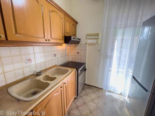 a kitchen with a sink and a refrigerator at Apartment Lampiri in Limenaria