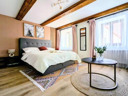 a bedroom with a large bed and a table at Penzion Na bezu in Drahonice