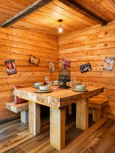 a wooden dining room with a wooden table in a cabin at Les Ecuries du Ranch in Les Cresnays