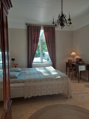a bedroom with a bed and a desk and a window at Villa Matilda in Uusikaupunki
