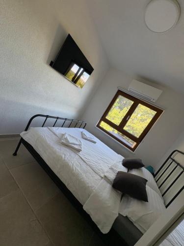 a bedroom with a large bed with a window at House RudNik in Silent Village, Island Krk in Isola Veglia