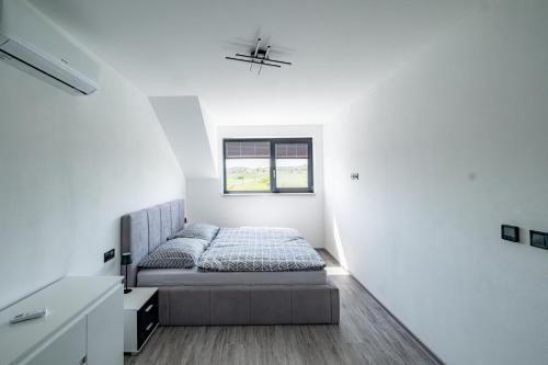 a bedroom with a bed in a white room at Apartmány Michelle in Dolní Dunajovice