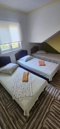 two beds sitting next to each other in a bedroom at Maca apartmani in Utjeha
