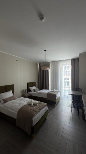 a hotel room with two beds and a piano at Apartamenty Nadjeziorna in Ełk