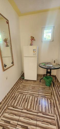 a room with a refrigerator and a table at Maca apartmani in Utjeha