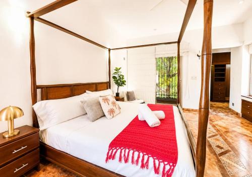 a bedroom with a canopy bed with a red blanket on it at Solanza Hotel Hacienda in Cancún
